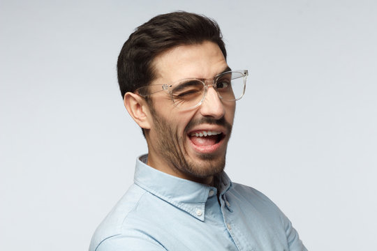 Handsome man smiling and winking, looking at camera