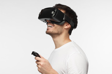 Close up portrait of handsome man playing video games in goggles or 3d glasses, wearing virtual...