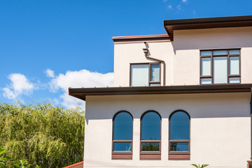 Perfect neighborhood. Top of residential townhouse on blue sky background