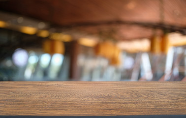 Empty wooden table in front of abstract blurred background of coffee shop . can be used for display or montage your products.Mock up for display of product.