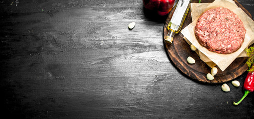 Raw burger with spices and herbs.