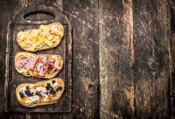 Sandwiches with seafood, salami, cheese and vegetables.