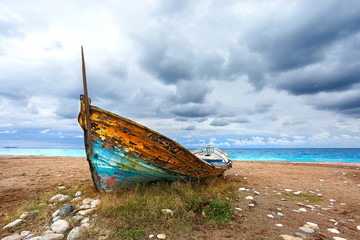 Landscape with wooden boat on the beach.