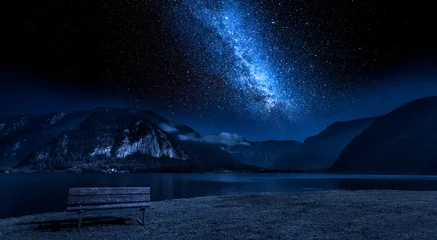 Schilderijen op glas Wooden bench and lake mountain between at night with stars © shaiith
