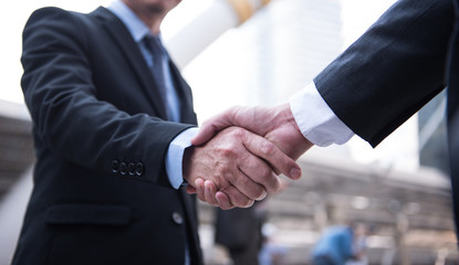 Business people shaking hands, Greeting Deal Concept, modern city background.