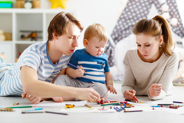Obraz premium children's creativity. happy family mother father and son draw together
