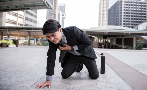 Business man is clutching his chest, acute pain possible heart attack with copy space.