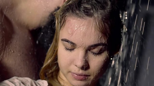 gentle young girl is pressed against her man naked in the rain