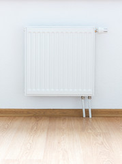 heating radiator against white wall - obrazy, fototapety, plakaty