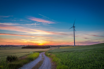 Fototapeta na wymiar Stunning dusk over field wind turbines in summer, Europe