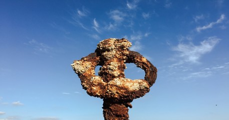 Rusty metal on blue sky with clouds background.