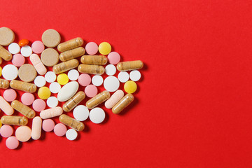 Medication white colorful round tablets arranged abstract on red color background. Aspirin, capsule...