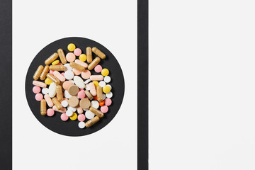 Medication white colorful round tablets arranged abstract in circle on white black background....