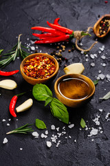 Fresh herbs and spices on black stone table