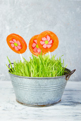 Spring concept. Candy lollipop flower in flowerpot with grass