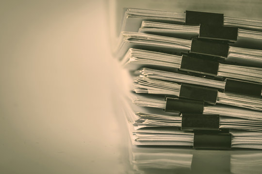 extreamely close up a report paper stacking of office working document , retro color tone