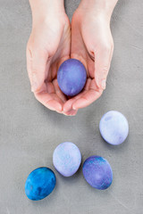 Female hand holding the violet Easter egg