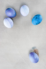Gray textured background with blue and violet Easter eggs