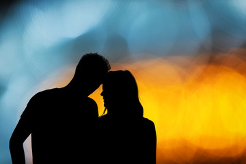 Silhouette of a couple with de-focused / bokeh lights.