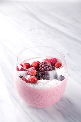 Smothie with red berries (raspberry, strawberry, blueberry, blackberry) in a glass. Frozen red fruits. Healthy breakfast