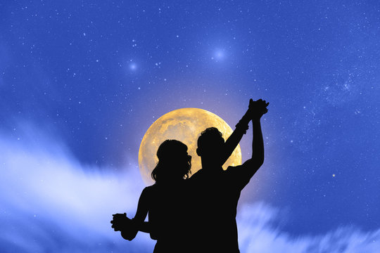 Young Couple Dancing Under The Moonlight And Stars. 