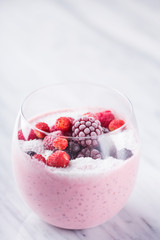 Smothie with red berries (raspberry, strawberry, blueberry, blackberry) in a glass. Frozen red fruits. Healthy breakfast