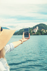 Girl photographing nice scenery on the lake.