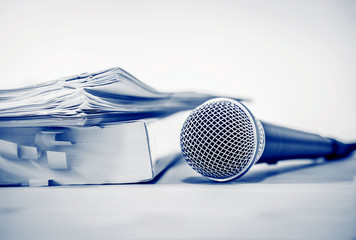 Close up a Microphone with paper document , concept of speaker or teacher preparation to speak in seminar class room