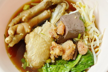 braised chicken leg and feet with bean sprout in herb brown soup on bowl