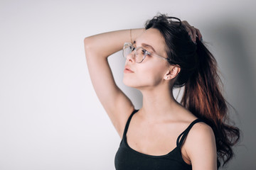 Woman in glasses and dreamy looks away