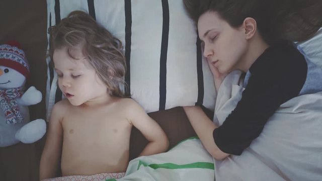 Мама и сын спят в кровати