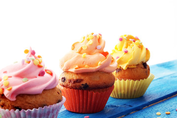 Tasty cupcakes on wooden background. Birthday cupcake in rainbow colors