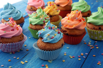 Tasty cupcakes on wooden background. Birthday cupcake in rainbow colors