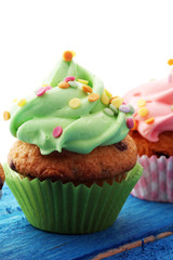 Tasty cupcakes on wooden background. Birthday cupcake in rainbow colors