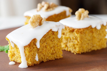 Pieces of homemade carrot cake with icing cream on white plate. Selective focus. Close up.