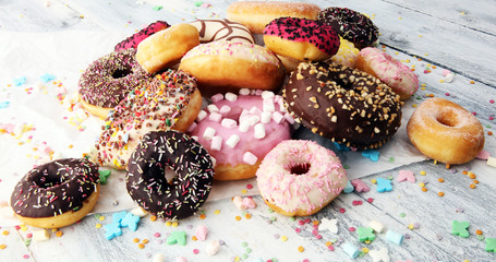 assorted donuts with chocolate frosted, pink glazed and sprinkles donuts.