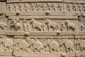 Stone bas-reliefs on the walls around the Vittala Temple in Hampi, Karnataka, India.