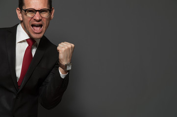 Good deal. Happy cheerful businessman in formal suit and glasses screams yes for joy. Place for text