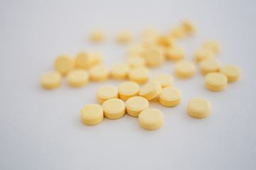Fototapeta na wymiar lots of little yellow pills on white background