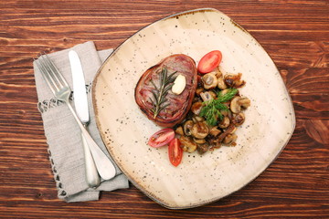 Tasty Beef steak with mushrooms and herbs on plate