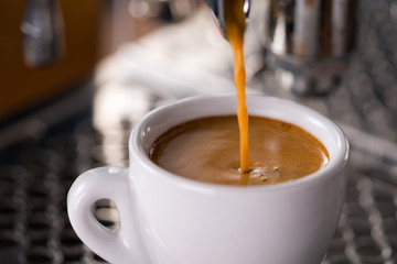 Espresso pour in cup with professional coffee machine