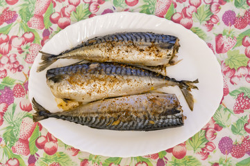 three baked fish on a white plate. Healthy food, seafood. Mackerel