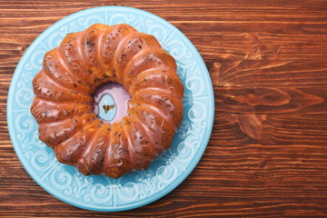 Bundt Cake with Sugar Icing on a wooden background
