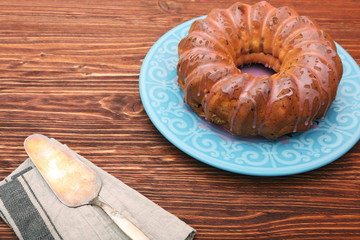 Bundt Cake with Sugar Icing on a wooden background