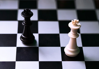 White and black chess figures on board. Chess game position. Black and white king.