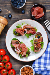 Toast of rye bread with jamon, blueberries and almonds. Snack with a proshoto!