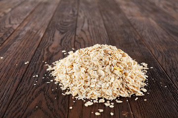 Healthy eating concept. Dry rolled oatmeal on wooden table