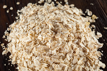 Healthy eating concept. Dry rolled oatmeal on wooden table