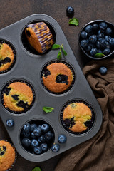 Homemade vanilla muffins with blueberries on a dark concrete background.Rustic!