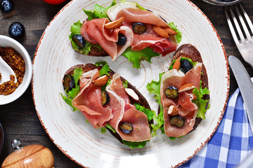 Toast of rye bread with jamon, blueberries and almonds. Snack with a proshoto!